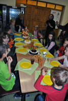 Uczestnicy imprezy przy urodzinowym stole.